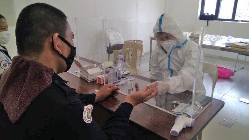 Devex safety personnel is seen administering a COVID-19 rapid test.
