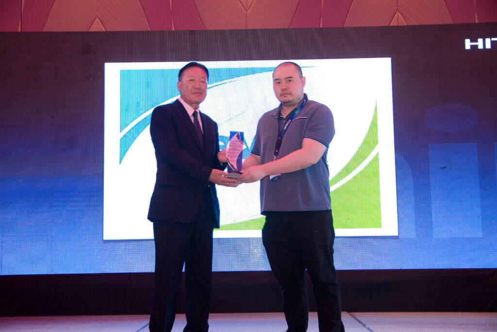 Hsueh-Yuan Huang (Johnson Controls-Hitachi Air Conditioning Sales Taiwan Co., Ltd.) presents a Platinum Award to Charles Ng (Devex Incorporated).