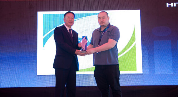 Hsueh-Yuan Huang (Johnson Controls-Hitachi Air Conditioning Sales Taiwan Co., Ltd.) presents a Platinum Award to Charles Ng (Devex Incorporated).